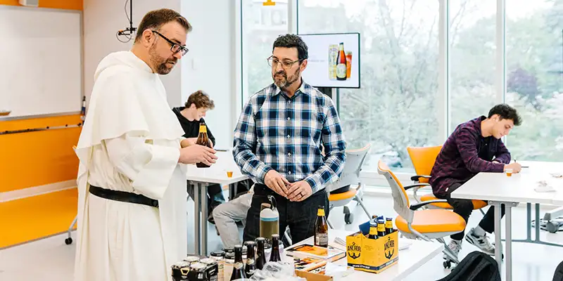 Father Jordan and Jay Pike prepare beer samples for tasting