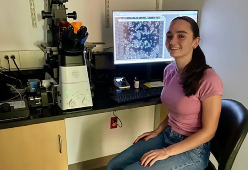 Cabral with a microscope in the Miller Lab