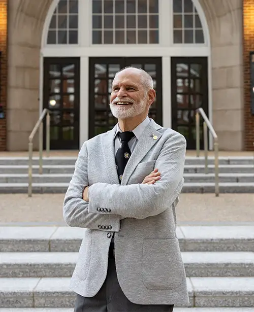 NAA President, Richy Kless ’74, ’78G, ’82SCE posing in front of the Smith Center for the Arts